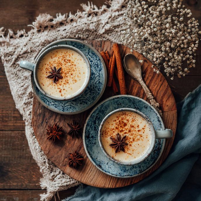 Top view of two Homemade Chai Tea Lattes on a cutting board