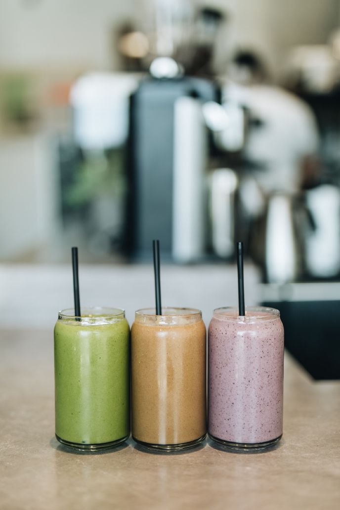 Three smoothies in a row on a cafe counter